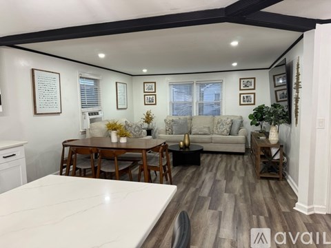 A living room with a couch, table, and chairs.