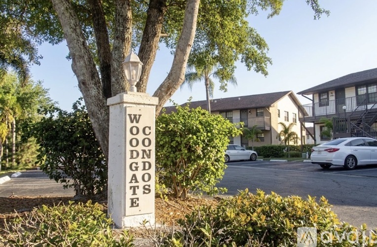 A white pillar with the words "Woodgates" written on it in black letters.