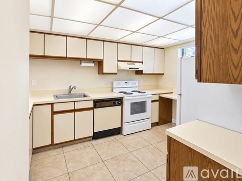 A kitchen with a white stove top oven and white dishwasher.