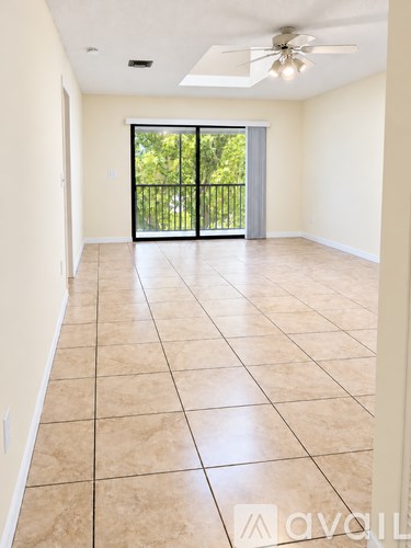 A spacious room with tiled flooring and a ceiling fan.