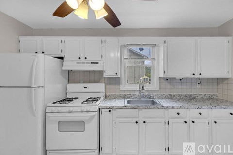 A kitchen with white appliances and cabinets.
