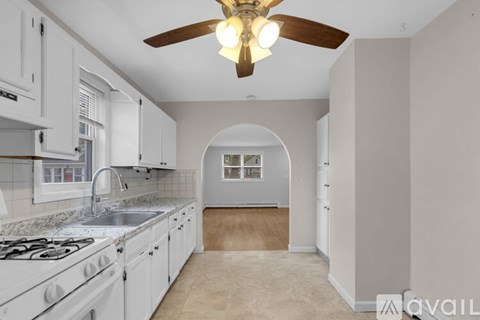 A kitchen with white cabinets and a marble countertop.