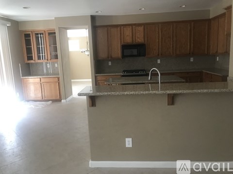 A kitchen with brown cabinets and a granite countertop.