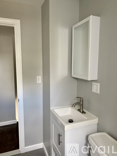 A white sink is on a white cabinet in a bathroom.