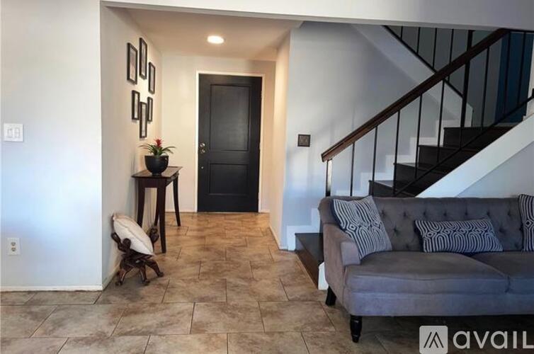 A living room with a grey couch and a black door.