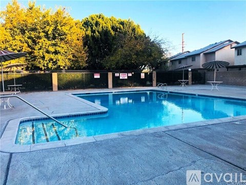 A pool with a slide and a sun umbrella.