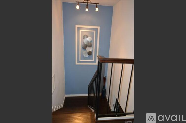 A staircase with a blue wall and a picture frame on it.