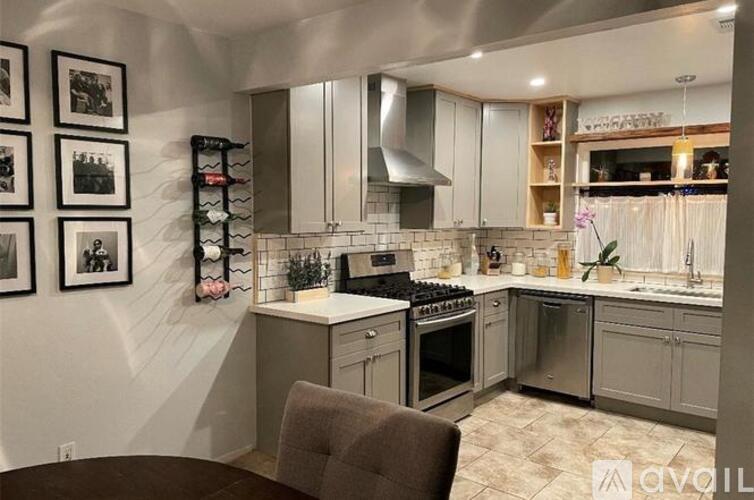 A modern kitchen with a dark brown chair in front of a white counter.