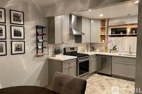 A modern kitchen with a dark brown chair in front of a white counter.