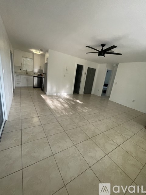 A spacious room with a ceiling fan and tiled flooring.