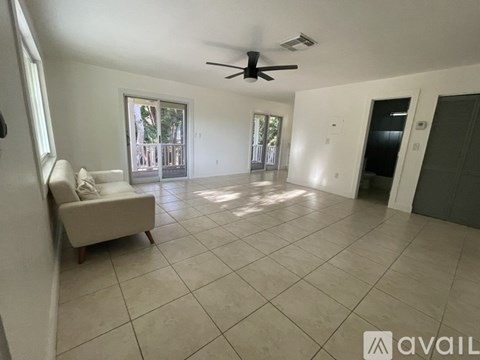 A spacious living room with a ceiling fan and a couch.
