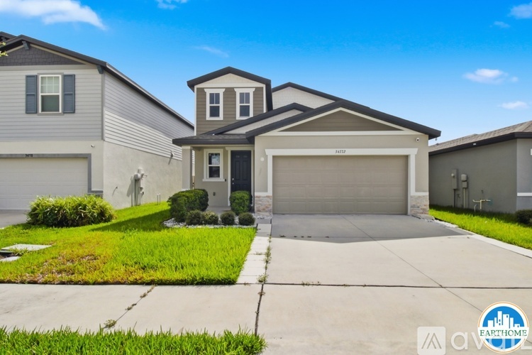 A two-story house with a garage is situated in a residential area.