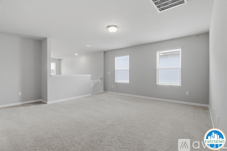 A spacious room with carpeted floor and a window with blinds.