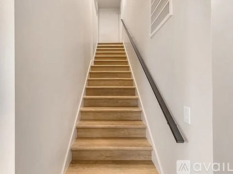 A staircase with wooden steps and a metal handrail.