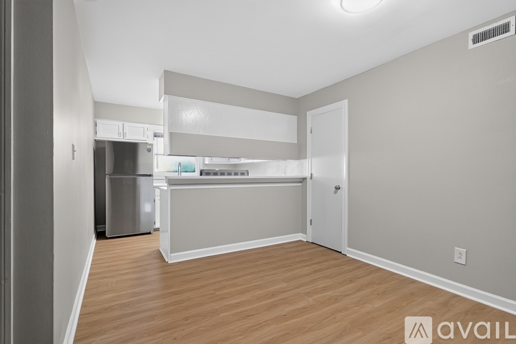 A spacious room with wooden flooring and a white countertop.