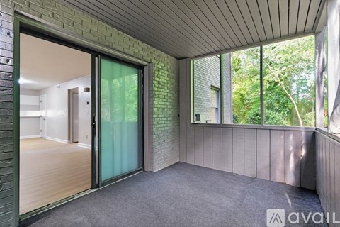 A room with a glass door and a brick wall.