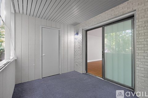 A room with a sliding glass door and a brick wall.
