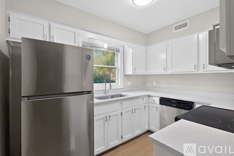 A modern kitchen with white cabinets and stainless steel appliances.