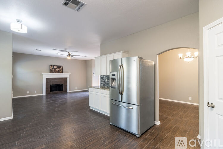 A kitchen with a stainless steel refrigerator and a fireplace.