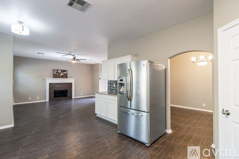 A kitchen with a stainless steel refrigerator and a fireplace.