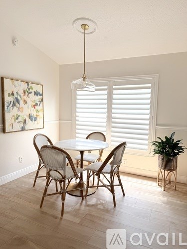 A dining room with a table and chairs.