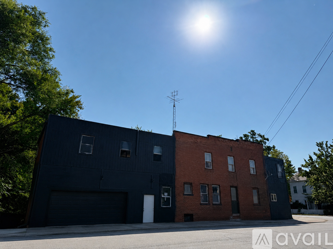 A building with a dark grey and a red section with a sun in the sky.