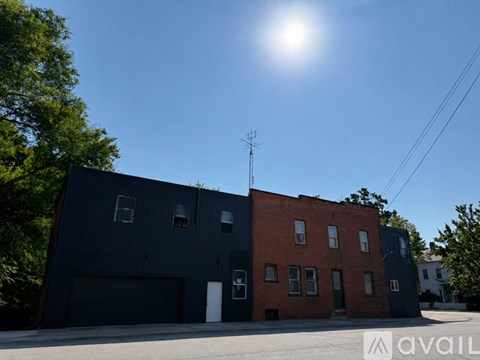 A building with a dark grey and a red section with a sun in the sky.