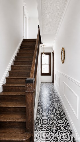 A staircase with a black and white tiled floor.