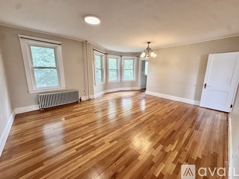 A room with wooden flooring and white walls.