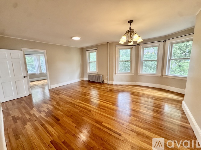 A room with wooden flooring and a chandelier.