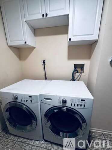 Two front load washing machines in a small laundry room.