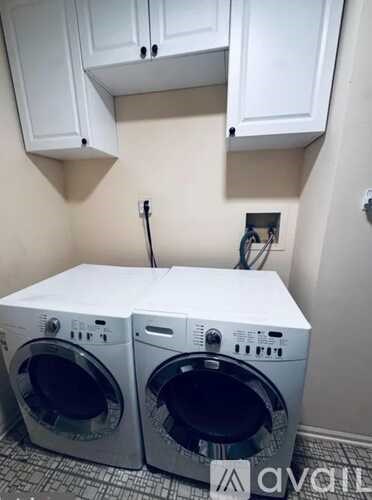 Two front load washing machines in a small laundry room.