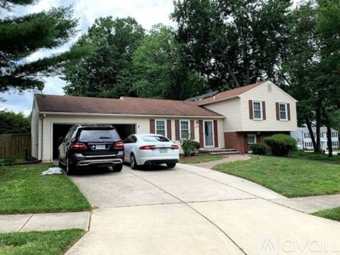 Two cars are parked in front of a house.