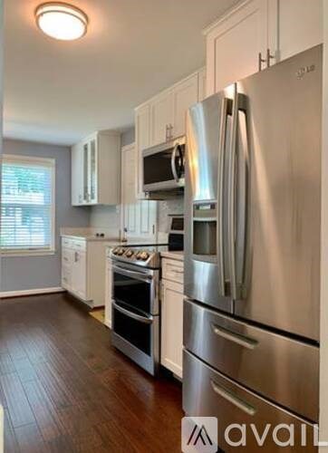 A kitchen with stainless steel appliances and wooden floors.
