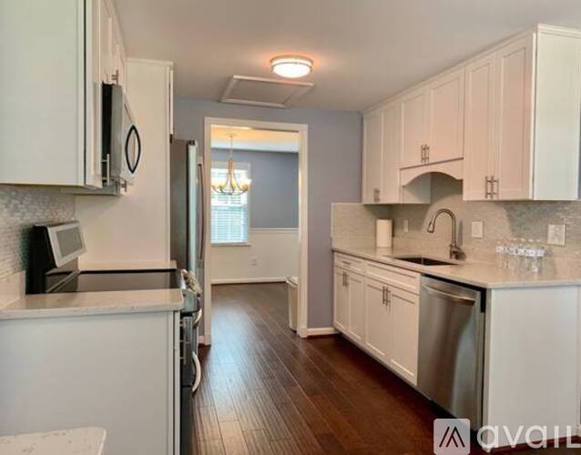 A kitchen with white cabinets and a stainless steel dishwasher.