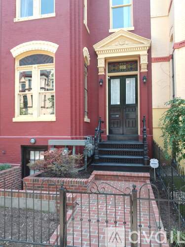 A red building with a black door and steps leading up to it.