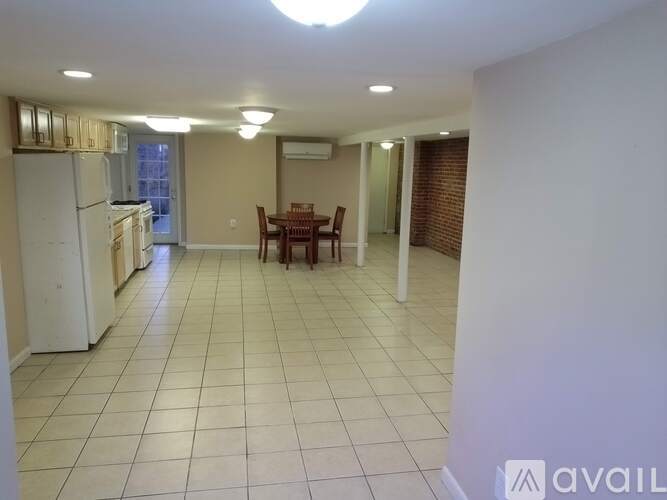 A kitchen with a refrigerator, table and chairs.