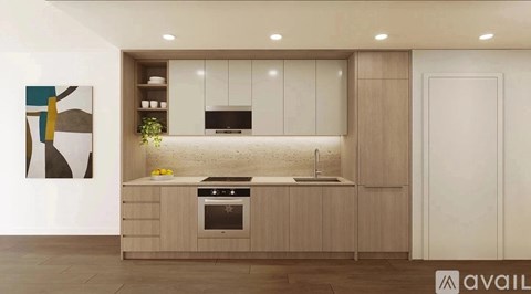 A modern kitchen with wooden cabinets and a black stove top oven.