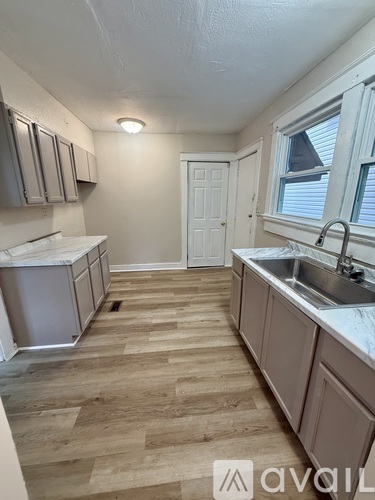 A kitchen with wooden floors and white appliances.