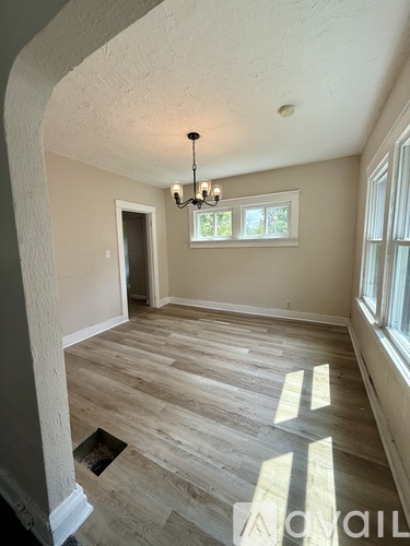 A room with wooden flooring and a chandelier.