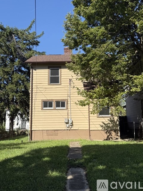 A house with a brown roof and a tree in front of it.