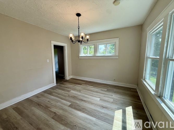 A room with wooden flooring and a chandelier.