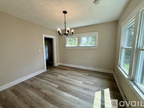 A room with wooden flooring and a chandelier.