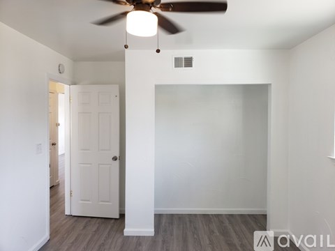 A room with a ceiling fan and a door.