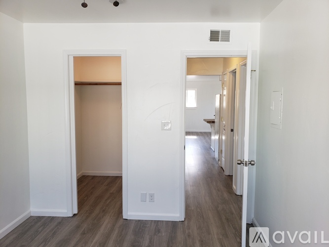 A hallway with a white door on the left and a white door on the right.