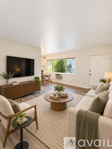 A living room with a flat screen TV, a sofa, a chair, and a coffee table.