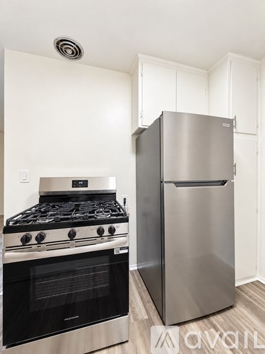 A modern kitchen with a stainless steel refrigerator and a stove top oven.