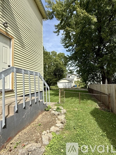 A house with a grey wall and a white door is shown.