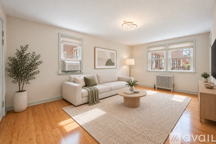 A living room with a white couch, a coffee table, and a potted plant.