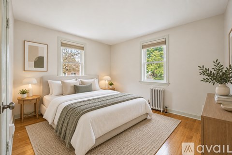 A bedroom with a large bed and a window showing trees outside.